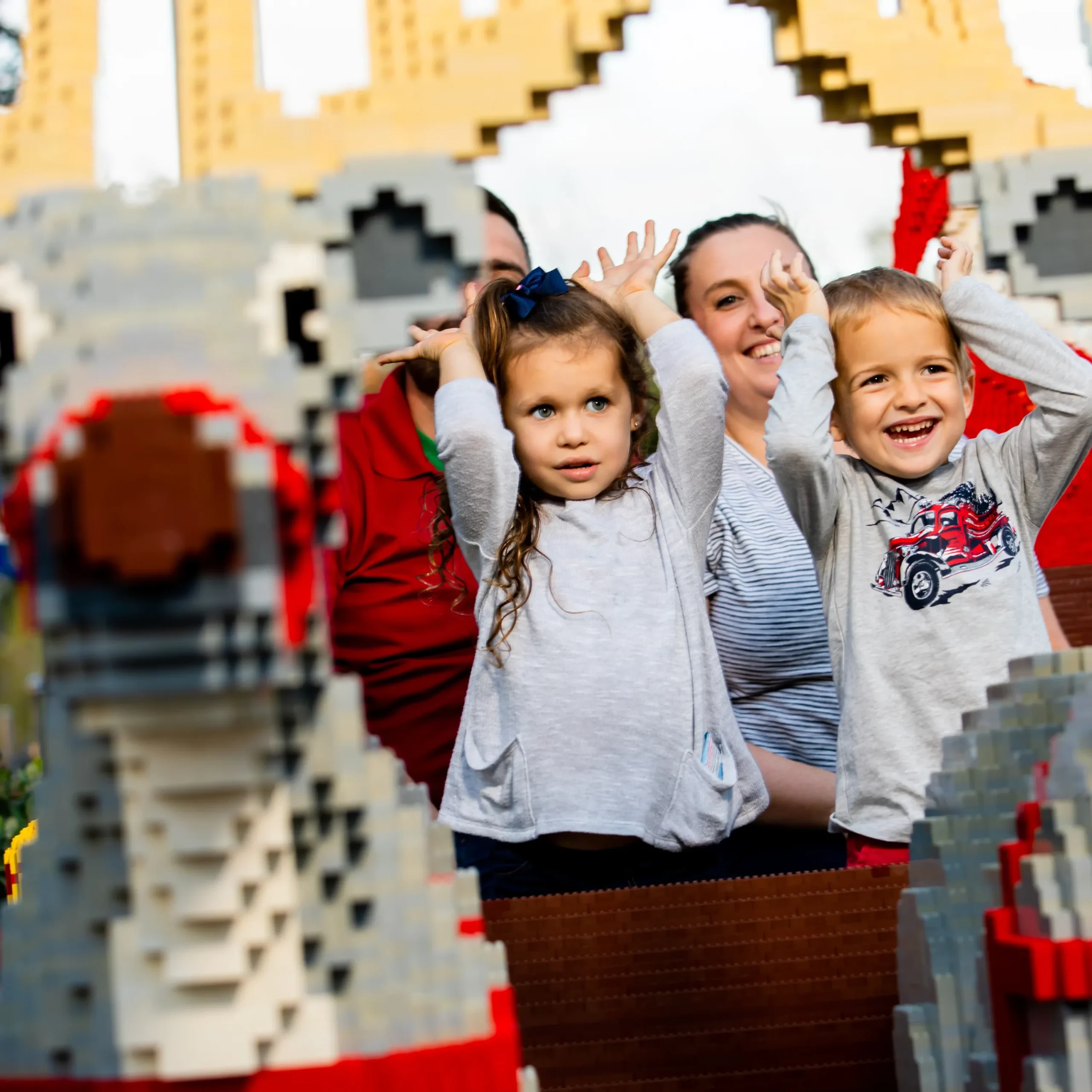 LEGOLAND Florida Christmas Bricktacular 2026: LEGO Santa Takes to the Sky 9 Family posing inside a LEGO sleigh beside brick built reindeer at LEGOLAND Florida
