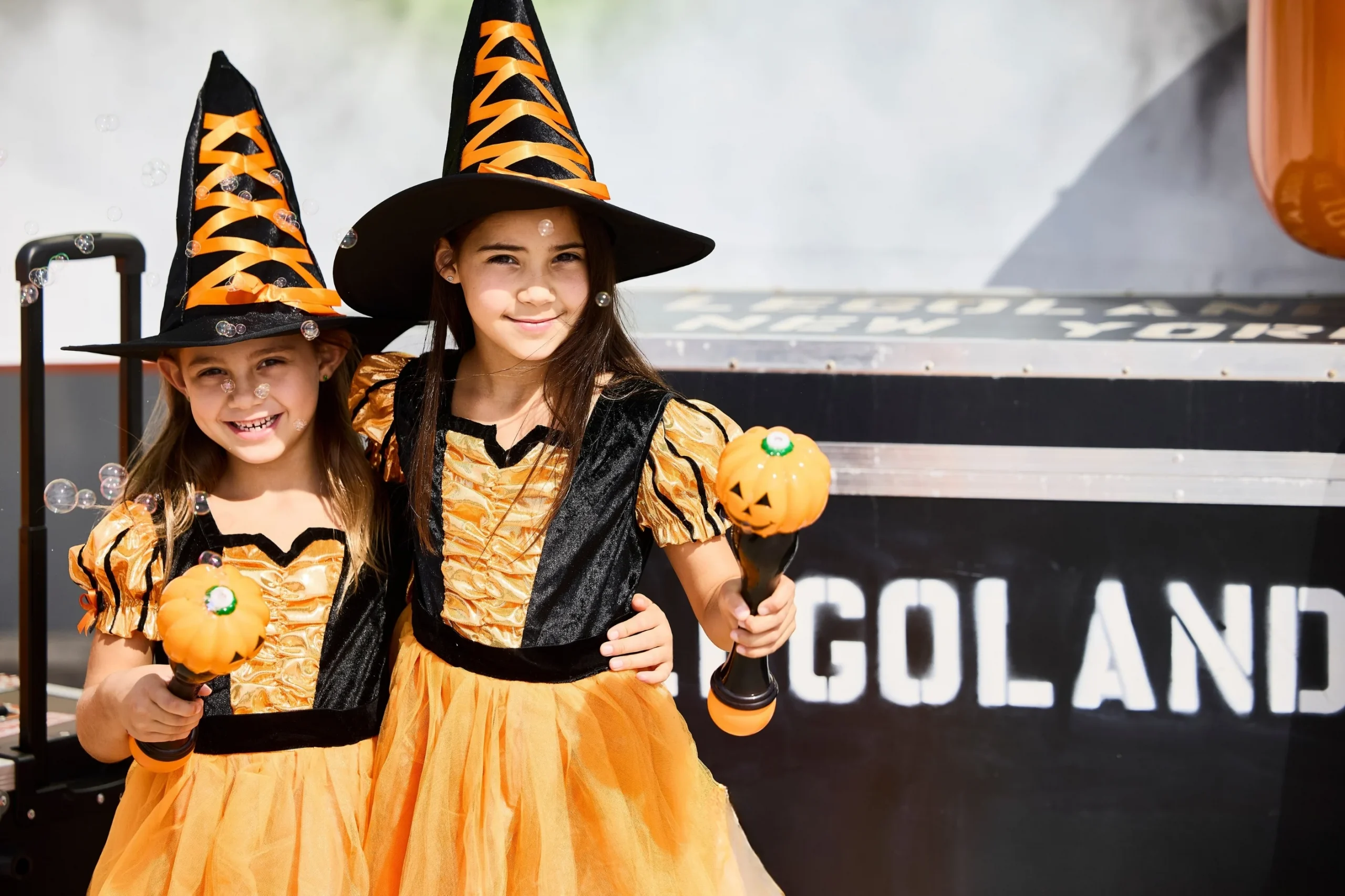 New for 2026: Brick or Treat Street at LEGOLAND Florida 7 Two children in orange witch costumes holding pumpkin bubble wands