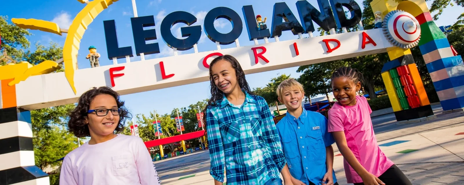 Orlando Theme Park Discount Tickets 2026: Save Up to 40% 4 Children walking beneath the LEGOLAND Florida entrance sign