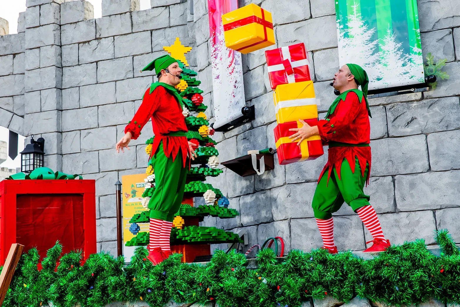 LEGOLAND Florida Christmas Bricktacular 2026: LEGO Santa Takes to the Sky 2 Holiday performers building a tall LEGO present display at LEGOLAND Florida
