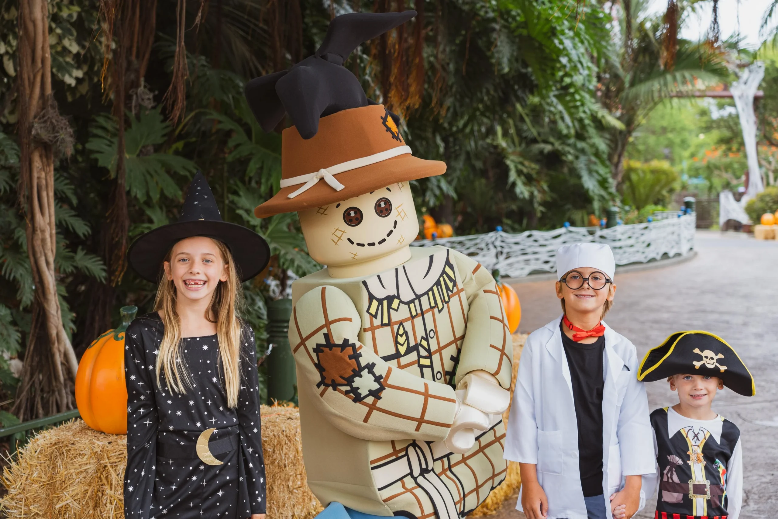 New for 2026: Brick or Treat Street at LEGOLAND Florida 3 Three costumed children posing with the LEGO Scarecrow character